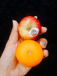 Close-up of hand holding orange