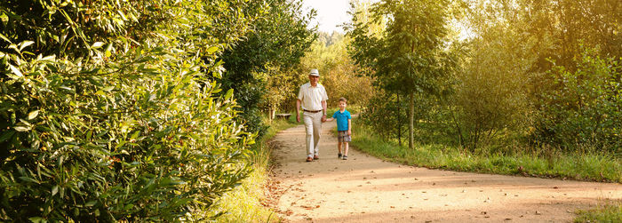 Portrait of grandfather and grandson walking at park