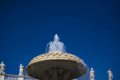 Low angle view of statue against blue sky