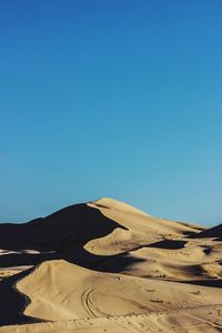 Scenic view of desert against clear blue sky