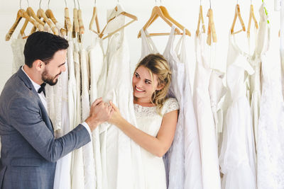 Happy young couple standing against wall