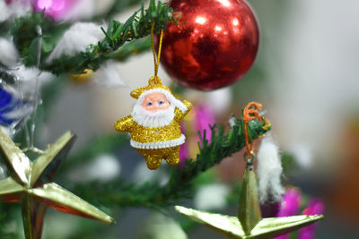 Close-up of golden santa claus hanging on christmas tree