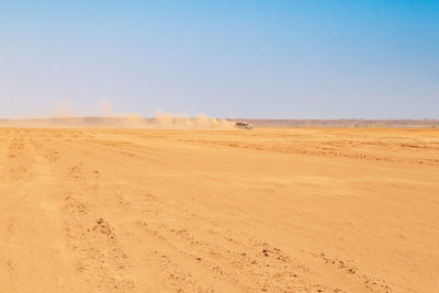 A tourist van on a dusty road against a desert landscapes in chalbi desert in marsabit county, kenya