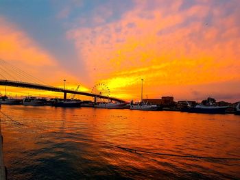 View of suspension bridge over river during sunset