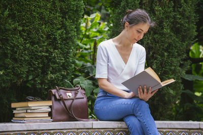 Young woman sitting on book