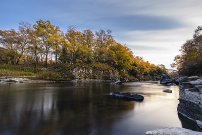 River flowing through rocks against sky