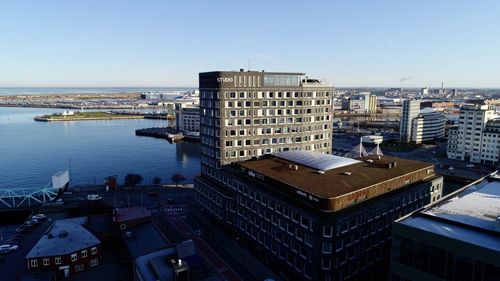 High angle view of buildings by sea against sky