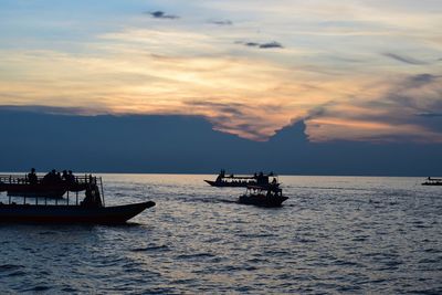 Boat sailing in sea against sky during sunset