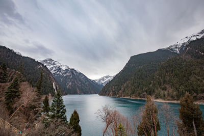 Scenic view of lake by mountains against sky