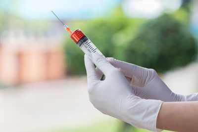 Cropped hands of doctor holding syringe