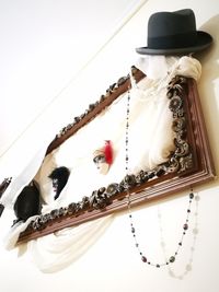 Close-up of hat hanging against white wall