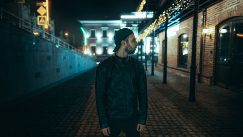 Man standing on footpath at night