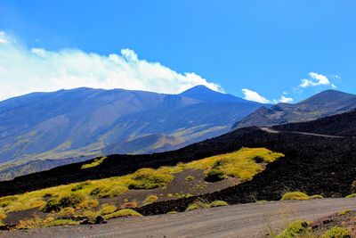 Scenic view of mountains against blue sky