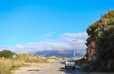 Cars on road against blue sky