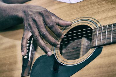 Cropped image of hand playing acoustic guitar