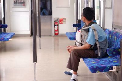 Side view of man sitting alone in the commuter line 