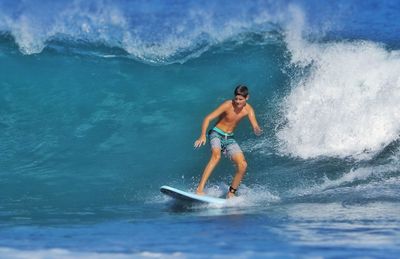 Full length of boy surfing in sea
