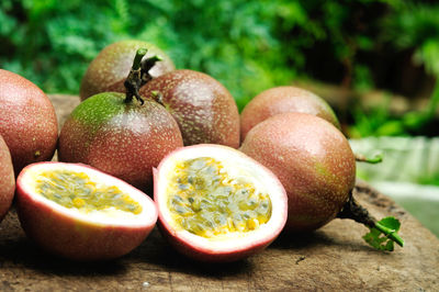 Close-up of passion fruits on cutting board against plants