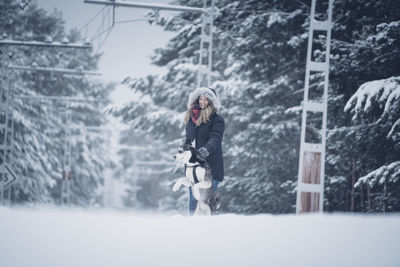 Woman on snow covered trees during winter