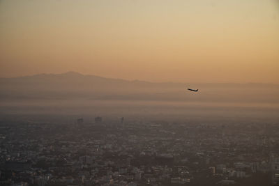 Aerial view of cityscape against sky during sunset