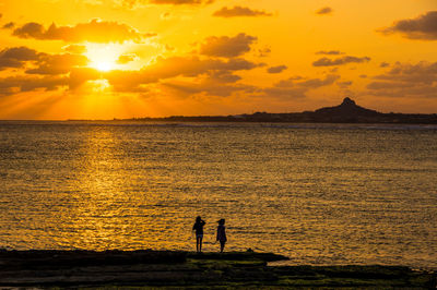 Scenic view of sea against orange sky