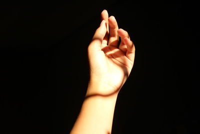 Close-up of human hand against black background