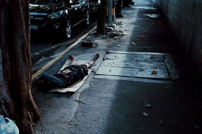 High angle view of homeless man sleeping on footpath