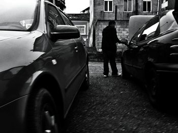 Rear view of woman standing on street in city