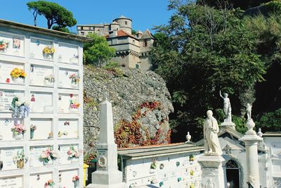 Low angle view of statues on building against trees