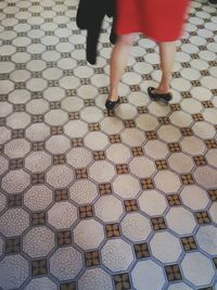 Low section of woman standing on tiled floor