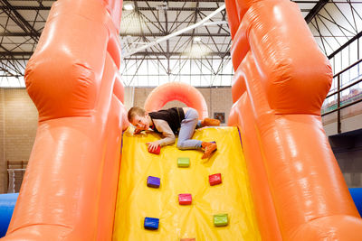 Rear view of children on slide at playground