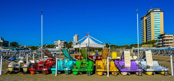 Chairs on beach against clear blue sky