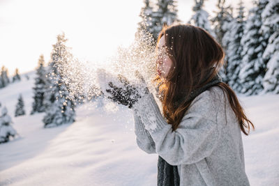 Rear view of woman standing on snow covered field