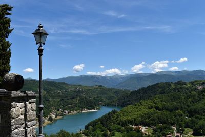 Street by river and mountains against sky