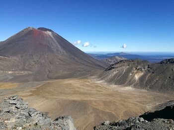 Scenic view of volcanic mountains against clear blue sky