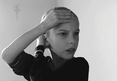 Portrait of boy looking down against white background