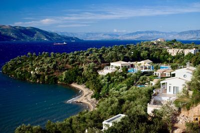 Scenic view of houses by sea against sky