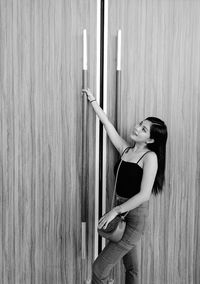 Side view of woman standing against wall