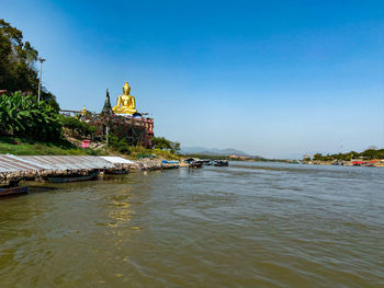 View of building by river against clear sky