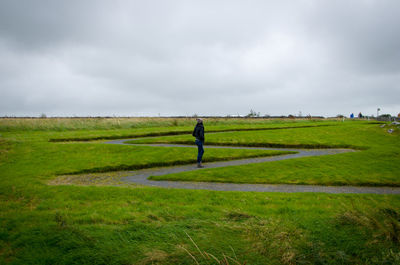 Man standing on agricultural field against sky