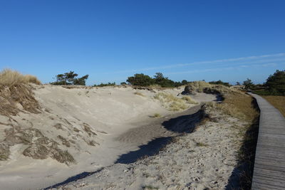 Panoramic view of land against clear blue sky