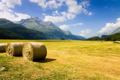 Hay bales on field against sky