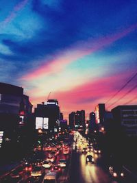 View of city lit up at sunset