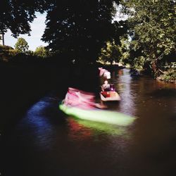 Children sitting on riverbank by river