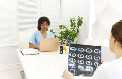 Young woman using digital tablet while sitting at home