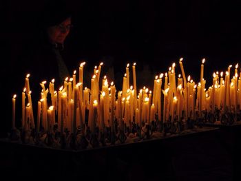 Close-up of lit candles against black background
