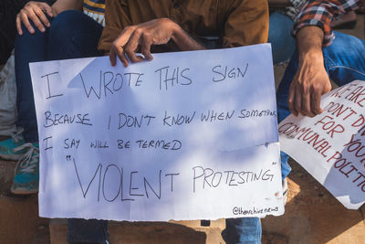 Midsection of man holding text on paper