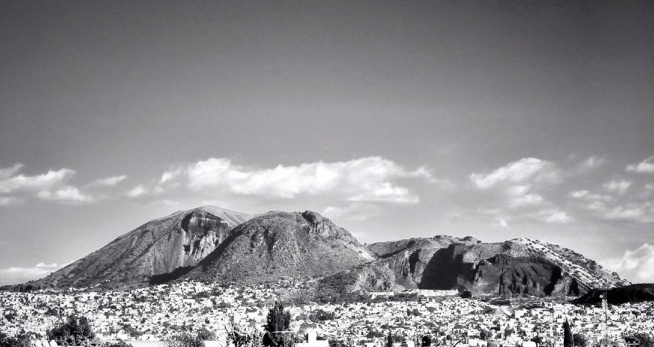 sky, mountain, tranquil scene, tranquility, scenics, landscape, beauty in nature, nature, rock formation, rock - object, cloud - sky, mountain range, cloud, low angle view, non-urban scene, remote, physical geography, geology, day, idyllic