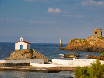 Church building by sea against sky