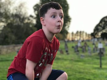 Shocked boy crouching on field